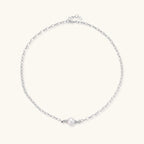 Dainty rhodium-plated silver chain necklace with centered 10mm freshwater pearl and crystal accents on cream background