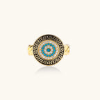 Gold chain ring with Greek key border and turquoise evil eye center on white background