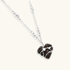 Dark ebony wood heart charms wrapped in intricate silver chains with crystal accents, shown as matching earrings and necklace set.