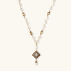 Y-shaped necklace with freshwater pearls, gold filigree stations, and ornate diamond-shaped centerpiece with pearl drop